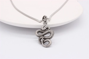 Macro shot of retro silver snake pendant showing detailed scales and vintage texture