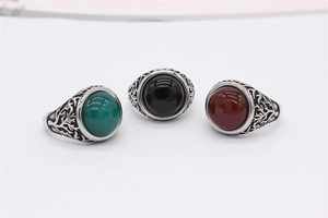 Macro detail of retro steel rings with oval gemstones and tree of life carvings