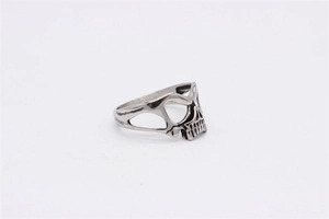 Detailed close-up of a vintage skull mask ring in polished silver stainless steel