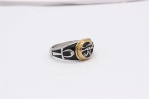 Macro detail of Egyptian Eye of Horus ring in retro steel with Ankh cross symbol