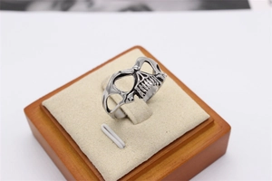 Macro shot of vintage skull mask ring with intricate hollow out details and aged steel finish