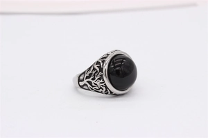 Macro shot of retro stainless steel ring featuring black gemstone and tree engraving