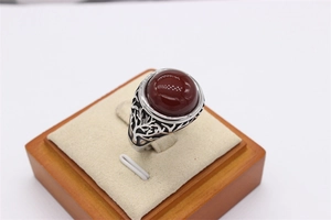 Macro shot of vintage titanium steel ring with red agate and Tree of Life engraving