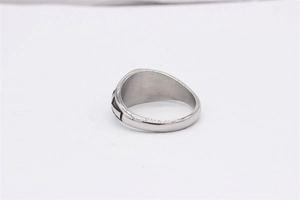 Macro shot of silver titanium steel ring with black etched geometric patterns on the side