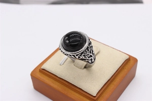 Macro detail of vintage tree of life ring with large black oval gemstone and silver finish