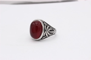 Vue macro de la bague vintage en acier avec pierre rouge et gravure de palmier