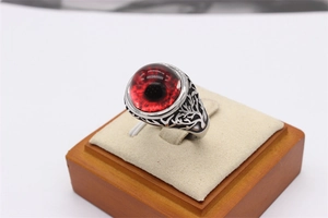 Macro shot of punk style tree of life ring with a large red round gemstone eye detail