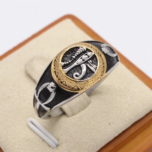 Ancient Egyptian Eye of Horus ring in silver and gold tones on a velvet box stand