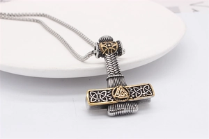 Macro detail of Thor's Hammer Mjolnir pendant with Valknut symbol and Celtic knot texture