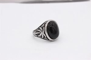 Détail d'une bague ovale à pierre noire avec motif de cocotier tropical gravé