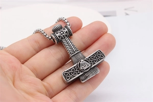Detail of Viking Thor Hammer necklace pendant with Celtic knots and Valknut engraving
