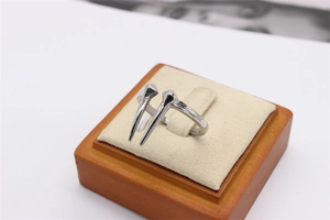 Macro shot of polished silver stainless steel ring with sharp spike details on a display