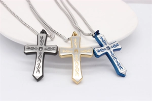 Vue détaillée de pendentifs croix en noir, or et bleu avec motifs de flammes sur plateau