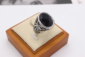 Vue latérale détaillée d'une bague vintage en acier avec pierre bleue et relief palmier