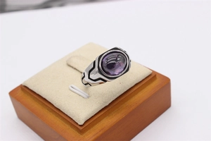 Macro view of vintage titanium steel ring with oval purple gemstone and engraved patterns
