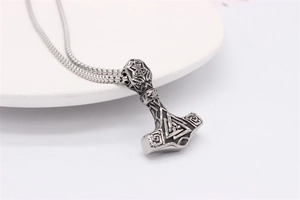 Macro shot of Viking Mjölnir pendant with Valknut symbol and Celtic knot textures