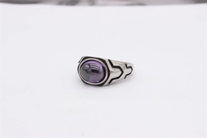 Detail of vintage titanium steel ring with oval purple gemstone and black geometric accents