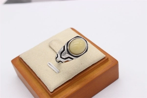 Macro shot of retro stainless steel ring featuring a cream oval stone and geometric carvings