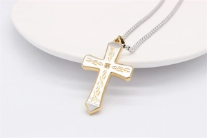 Détail du pendentif croix avec placage en or, texture brossée argentée et pierre de zircon