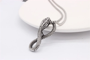 Detailed close-up of retro cobra pendant scales and texture on stainless steel chain