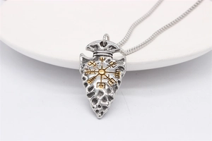Close-up of Viking arrow pendant with golden Vegvisir compass on vintage steel