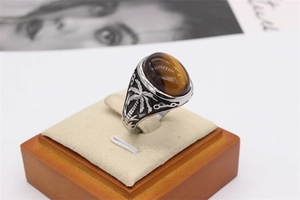 Relief détaillé de palmiers sur l'anneau en acier argenté de cette bague oeil de tigre