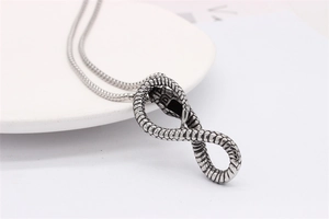 Detailed view of silver cobra necklace with scales texture on infinite snake pendant