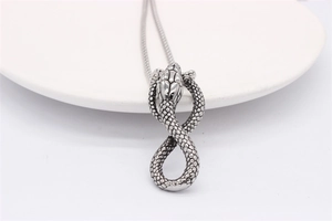 Close-up of retro cobra pendant showing detailed scales on polished stainless steel