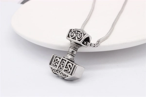 Gros plan du pendentif marteau de Thor Mjölnir avec nœuds celtiques et chaîne box