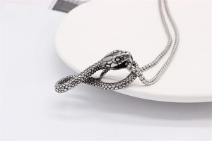 Macro detail of silver vintage cobra pendant with intricate scale carving and box chain