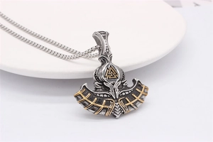 Detail of Viking axe pendant with gold Valknut symbol on a silver antique steel chain