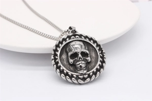 Macro shot of retro skull pendant with detailed wheat ear engraving on round steel disc
