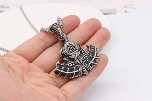 Macro detail of vintage Viking battle axe pendant with Valknut symbol on a steel chain