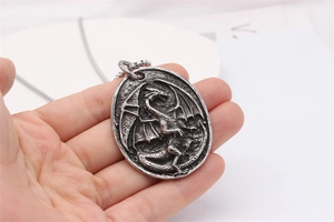 Macro shot of vintage silver dragon relief pendant with antique finish and fine engraving