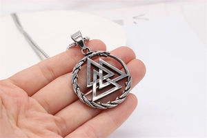 Detail of vintage silver Viking Valknut pendant with intricate Nordic knot textures