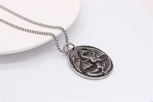 Macro shot of retro dragon relief pendant in antique silver finish with box chain