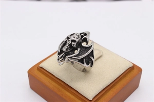 Macro shot of Gothic skull ring with flame wings and oxidized stainless steel finish