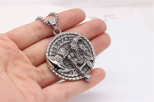 Détail du relief de corbeau et hache viking sur un pendentif en acier vintage