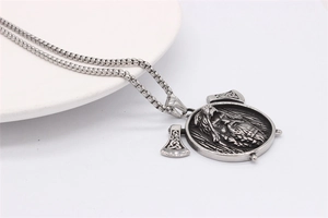 Detailed close-up of Viking axe pendant with Odin relief on polished box chain