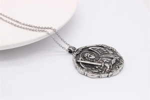 Macro shot of silver archangel pendant necklace with wings and cross detail