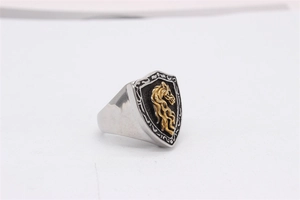 Détail d'une bague bouclier vintage en acier avec relief de tête de cheval doré et fleurs