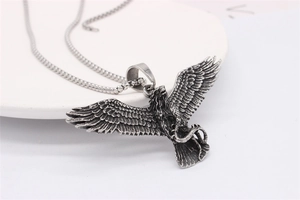 Detailed close-up of a vintage eagle and snake pendant in antique silver finish