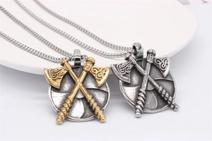 Vue macro de pendentifs double hache viking avec gravures nordiques en finitions or et argent