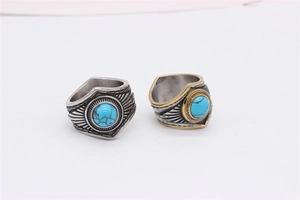 Detail of vintage steel feather rings featuring synthetic turquoise in retro silver finish