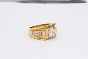 Detailed close-up of a chunky men's gold ring featuring a large center stone and pavé accents
