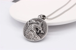 Detailed view of vintage silver viking wolf pendant necklace with nordic dragon relief