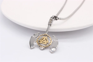Détail macro du pendentif hache viking avec symbole Valknut doré sur chaîne