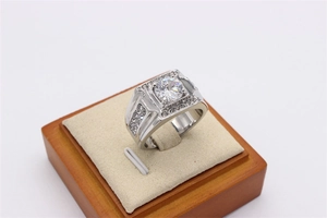 Close-up of men's titanium steel wedding ring with zircon inlay on a wood stand