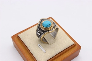 Detailed macro view of vintage feather ring with blue turquoise and two-tone steel finish