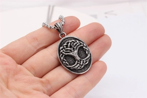 Macro shot of retro Tree of Life steel pendant showing oxidized silver details and box chain